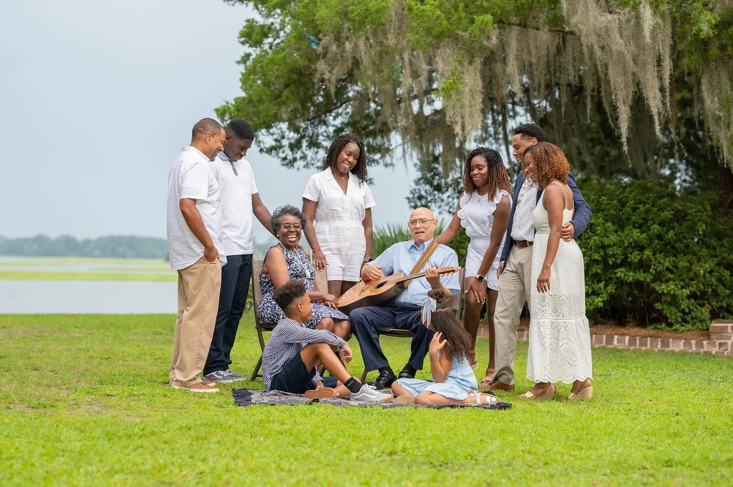 A Whole Family with Grandfather in the middle playing the guitar